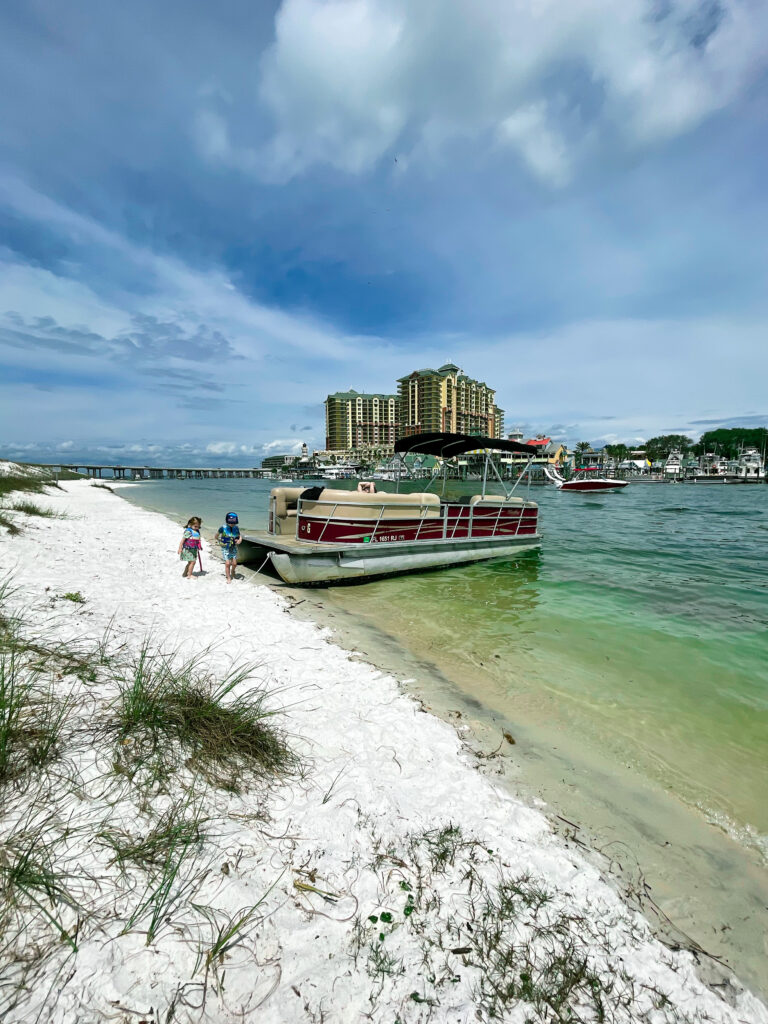 Pontoon boat on Norriego point with the Emerald Grande in the background, Destin, Florida